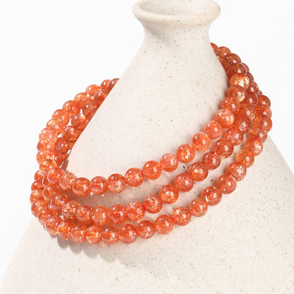 Sunstone beads draped around ceramic showing natural inclusions