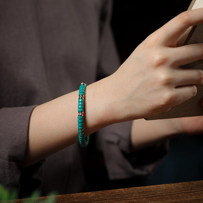 Teal tablet bead bracelet worn on the wrist