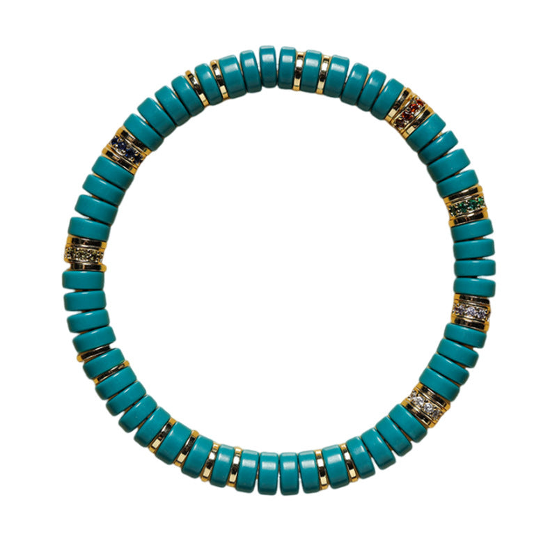 Overhead view of teal tablet bead bracelet on white background