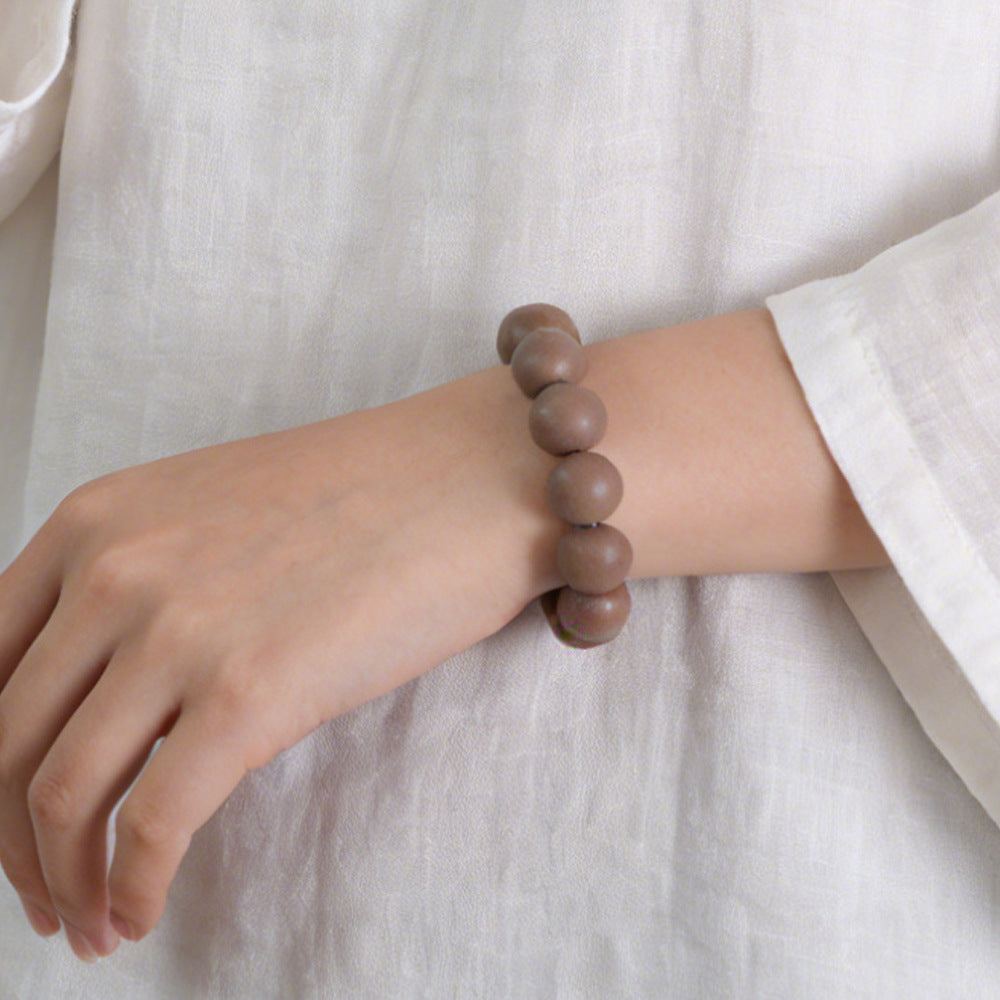 Brown incense bead bracelet worn on wrist