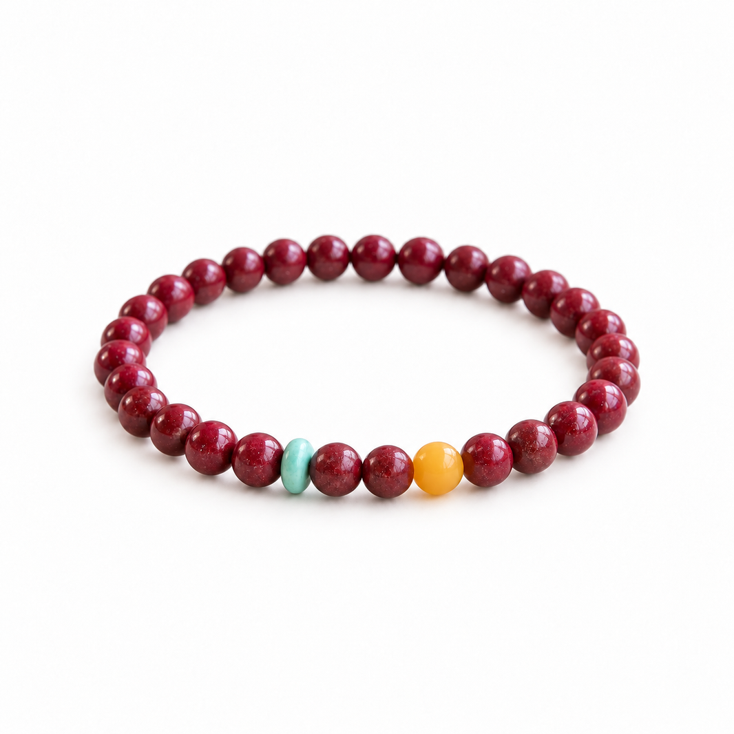 Burgundy red bead bracelet with turquoise-colored disc and yellow accent bead on white