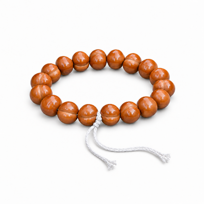 Polished walnut hand strand with white cord on a white background