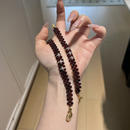 Close view of woven garnet beads and floral accents