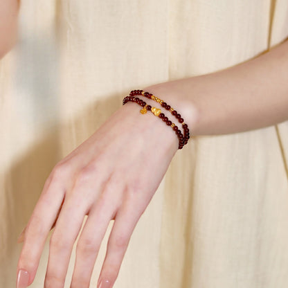 Garnet gourd and coin bracelet worn on the wrist