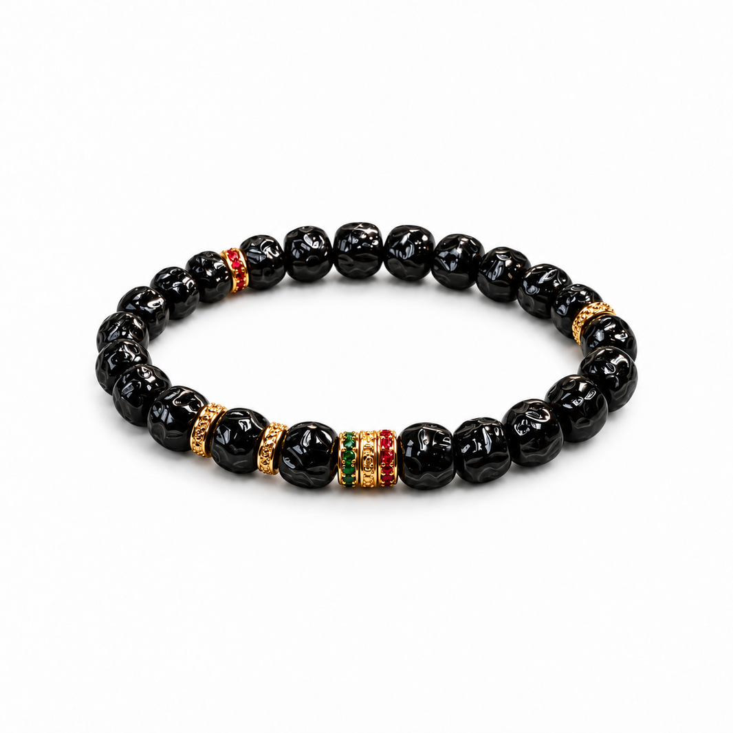 Sculpted black coconut pedicel bracelet with gold-tone and colored accents on white