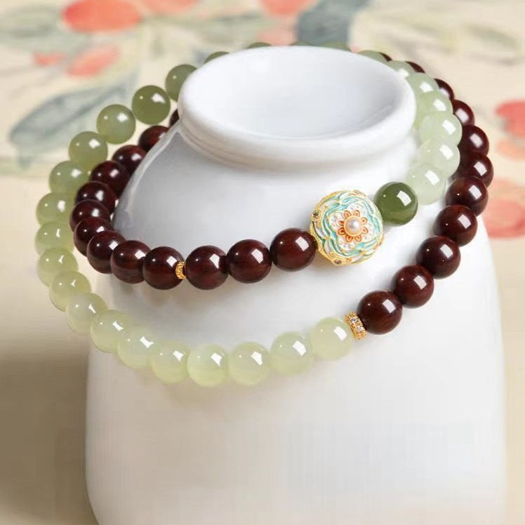 Wood and Hetian jade double-wrap bracelet displayed on a white cup