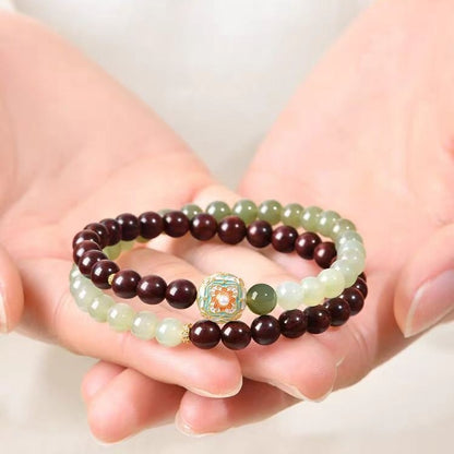Red sandalwood and Hetian jade bracelet held for scale