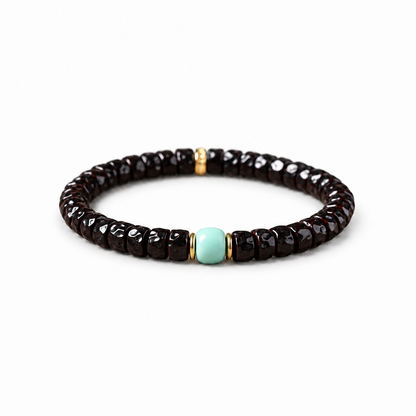Sculpted dark coconut-pedicel bracelet with pale blue centerpiece on white