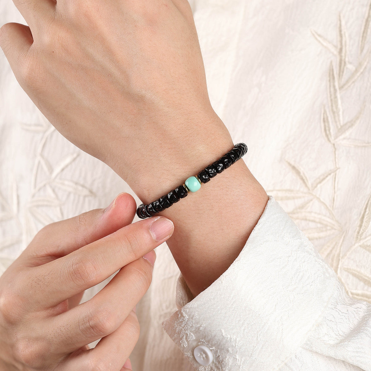 Slim coconut-pedicel bracelet worn on a wrist