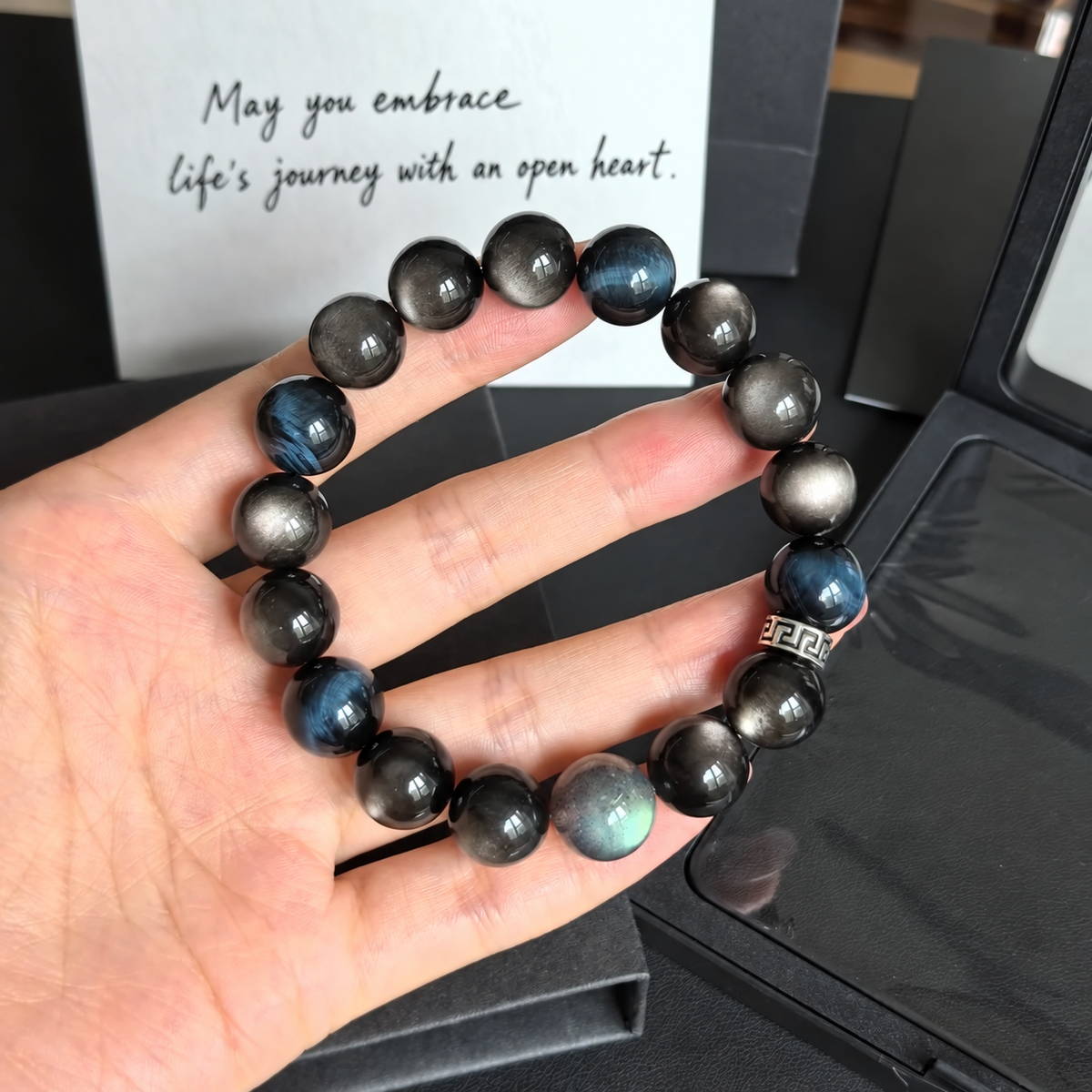 12 mm blue tiger eye and silver sheen obsidian bracelet shown in hand