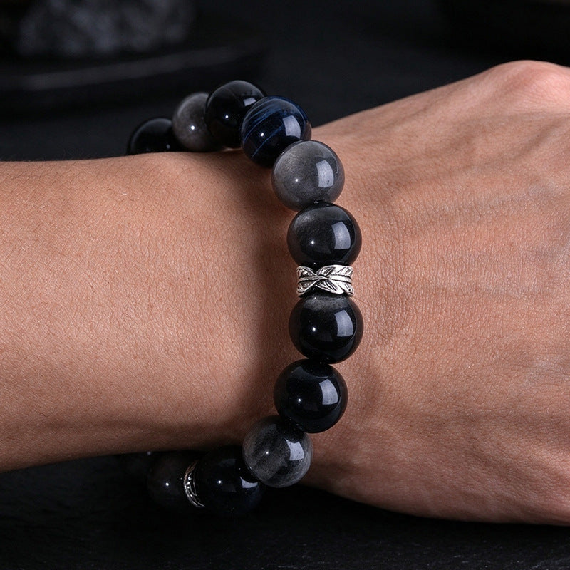 Blue tiger eye and silver-sheen obsidian bracelet worn on a wrist