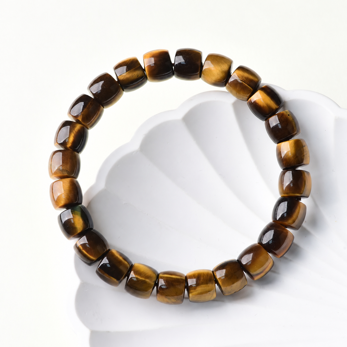 Golden tiger eye barrel-bead bracelet on a white display prop