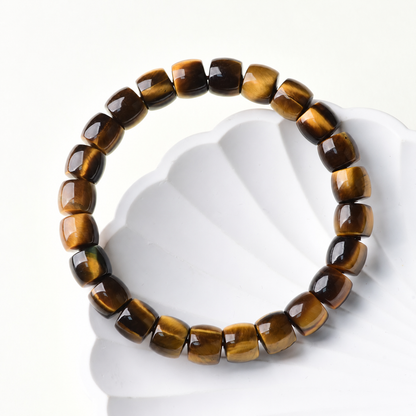 Golden tiger eye barrel-bead bracelet on a white display prop