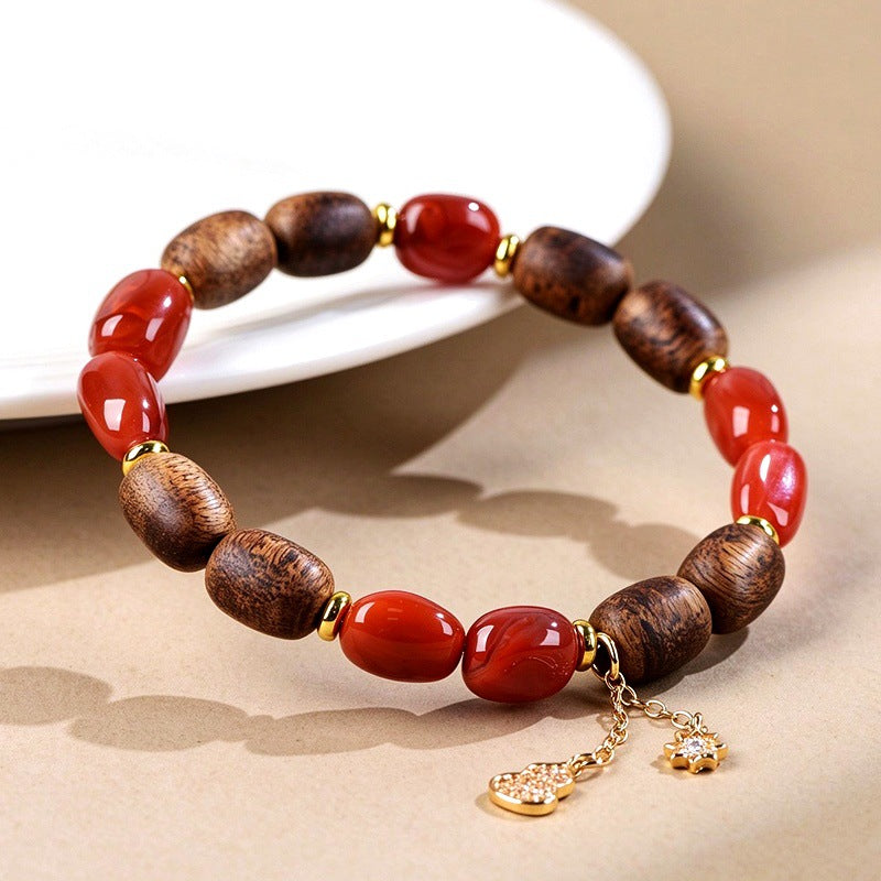 Red agate and agarwood bracelet displayed beside a white dish
