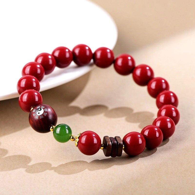 Cinnabar and green jade bracelet on a display dish