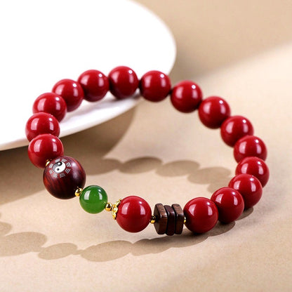 Cinnabar and green jade bracelet on a display dish