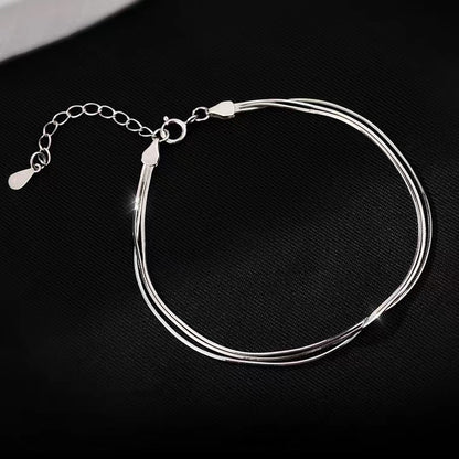 S925 triple-strand snake chain bracelet on dark fabric
