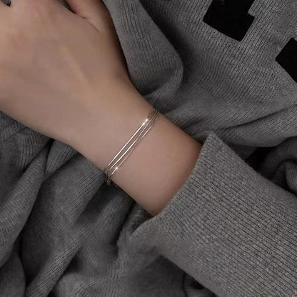 Three-strand sterling silver bracelet worn on the wrist