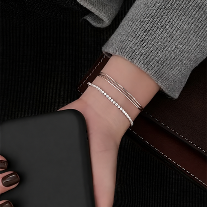 Silver snake chain bracelet styled beside a separate stone-set bracelet