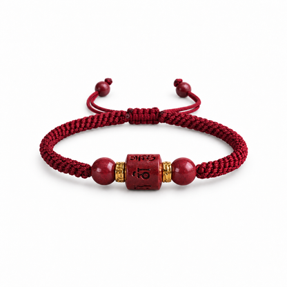 Burgundy braided cord bracelet with engraved red cinnabar barrel on white
