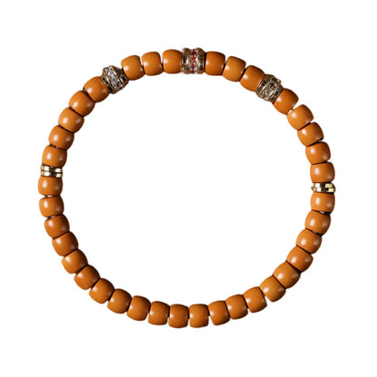 Olive pit bead bracelet with decorative spacers on white