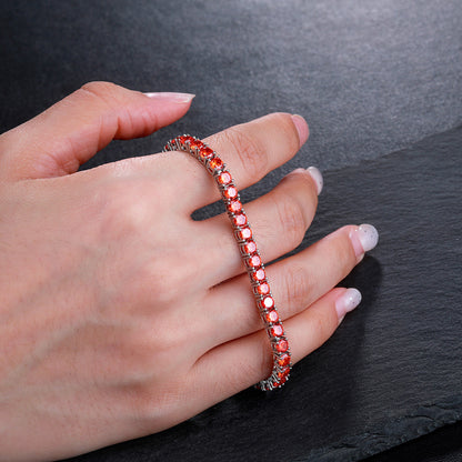 Orange red zircon tennis bracelet held for a close view