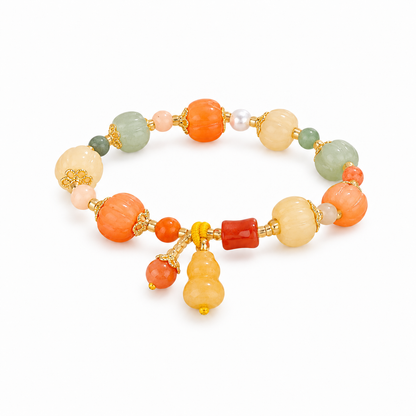 Multicolor carved pumpkin bead bracelet with centered yellow gourd charm on white