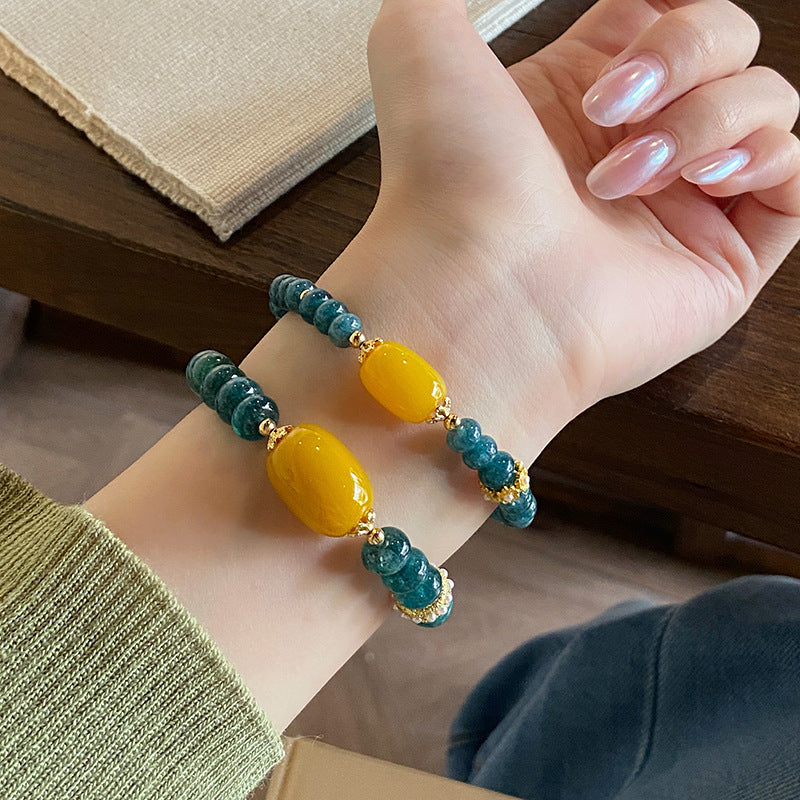 Two sizes of teal chalcedony and yellow agate bracelets worn on wrist