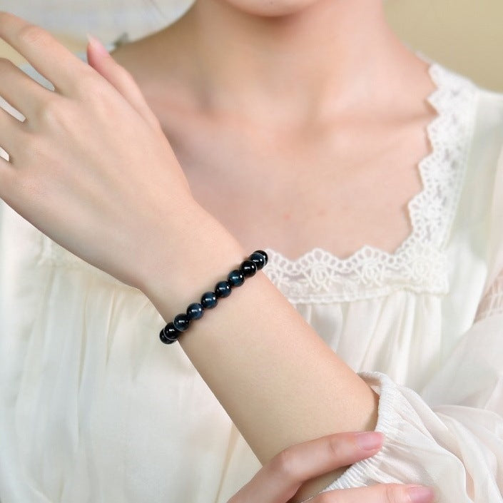 Blue tiger eye single-wrap bracelet worn on a wrist