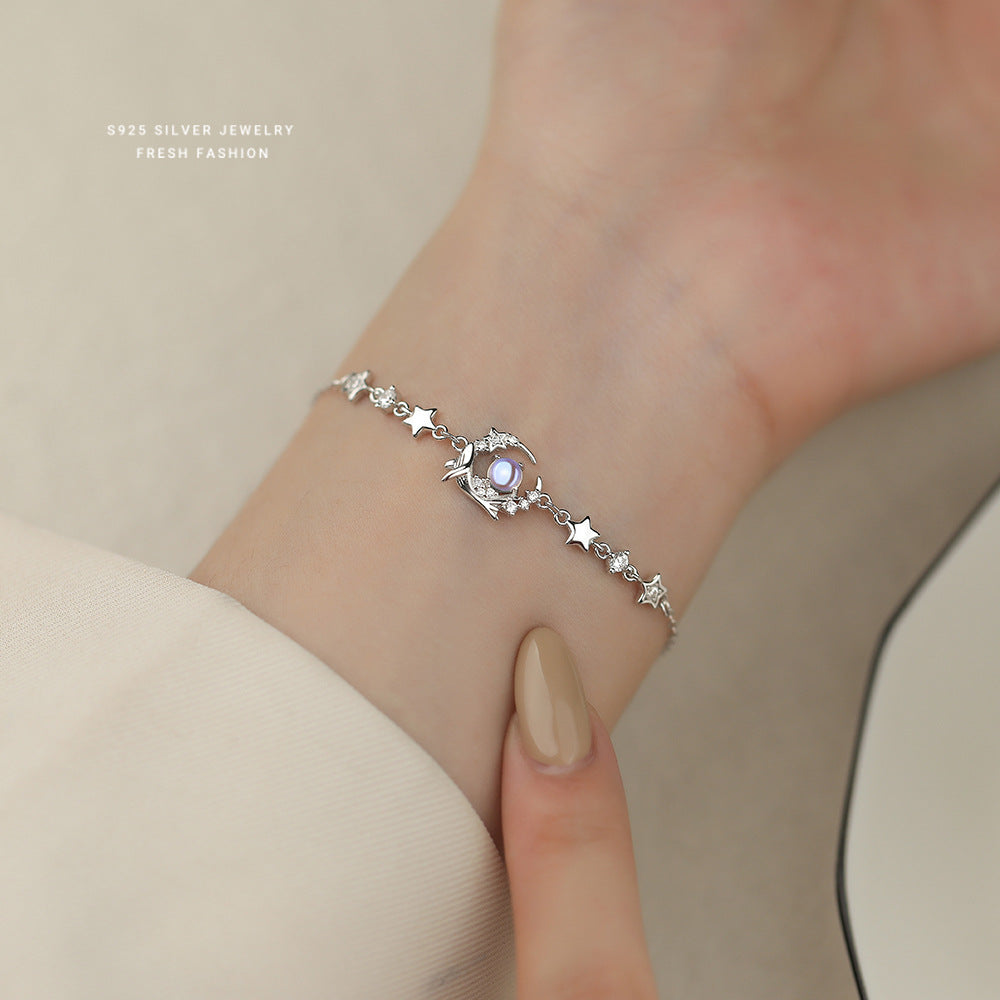 Wrist styling of silver whale bracelet with luminous blue glass