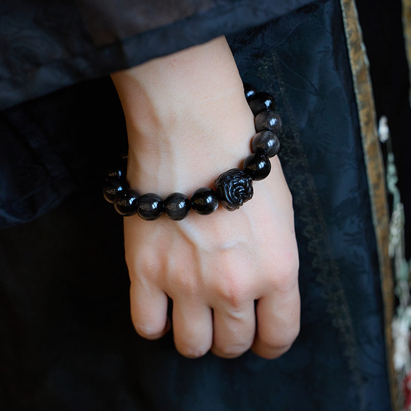 Silver-sheen obsidian lion-dance bracelet worn on wrist