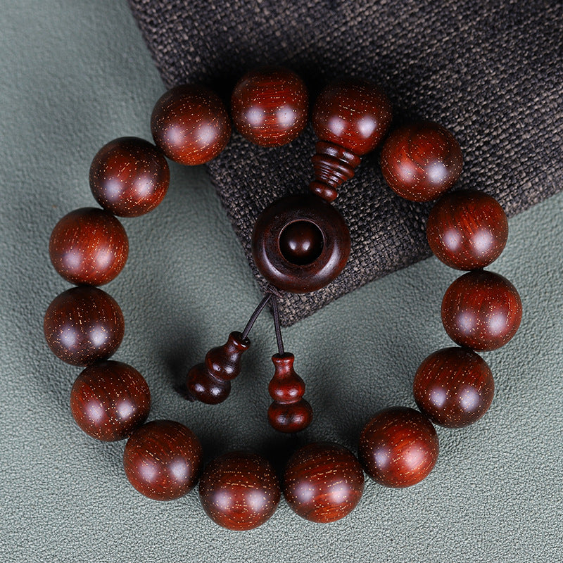 Red sandalwood bracelet with ring and gourd details on dark cloth