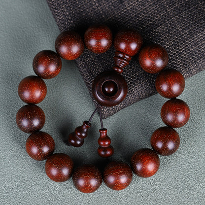 Red sandalwood bracelet with ring and gourd details on dark cloth