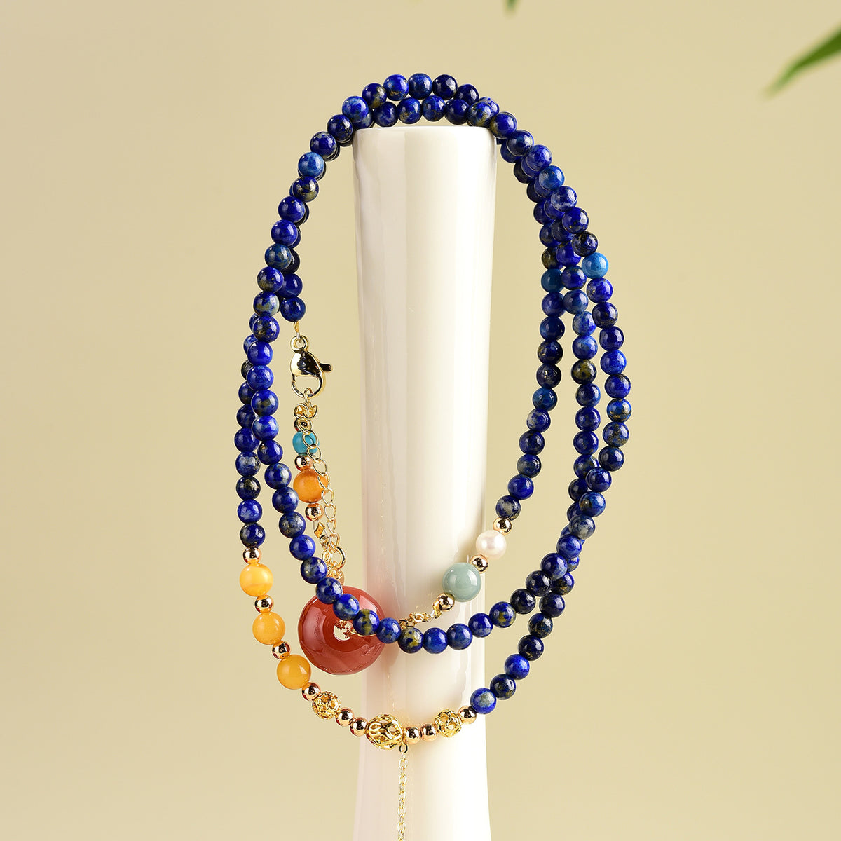 Lapis lazuli and amber necklace displayed on a white stand