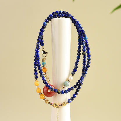 Lapis lazuli and amber necklace displayed on a white stand