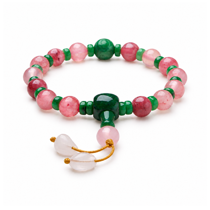 Pink patterned bead bracelet with green spacers, green connector and two white leaf drops on white