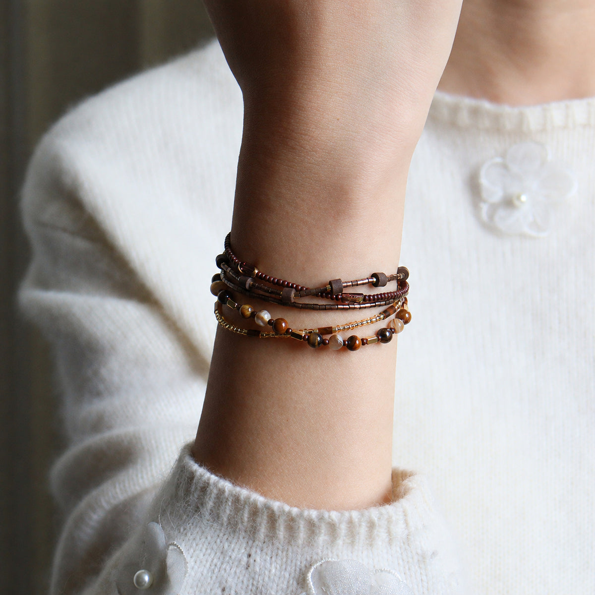Shell bead multi-row bracelet worn on wrist