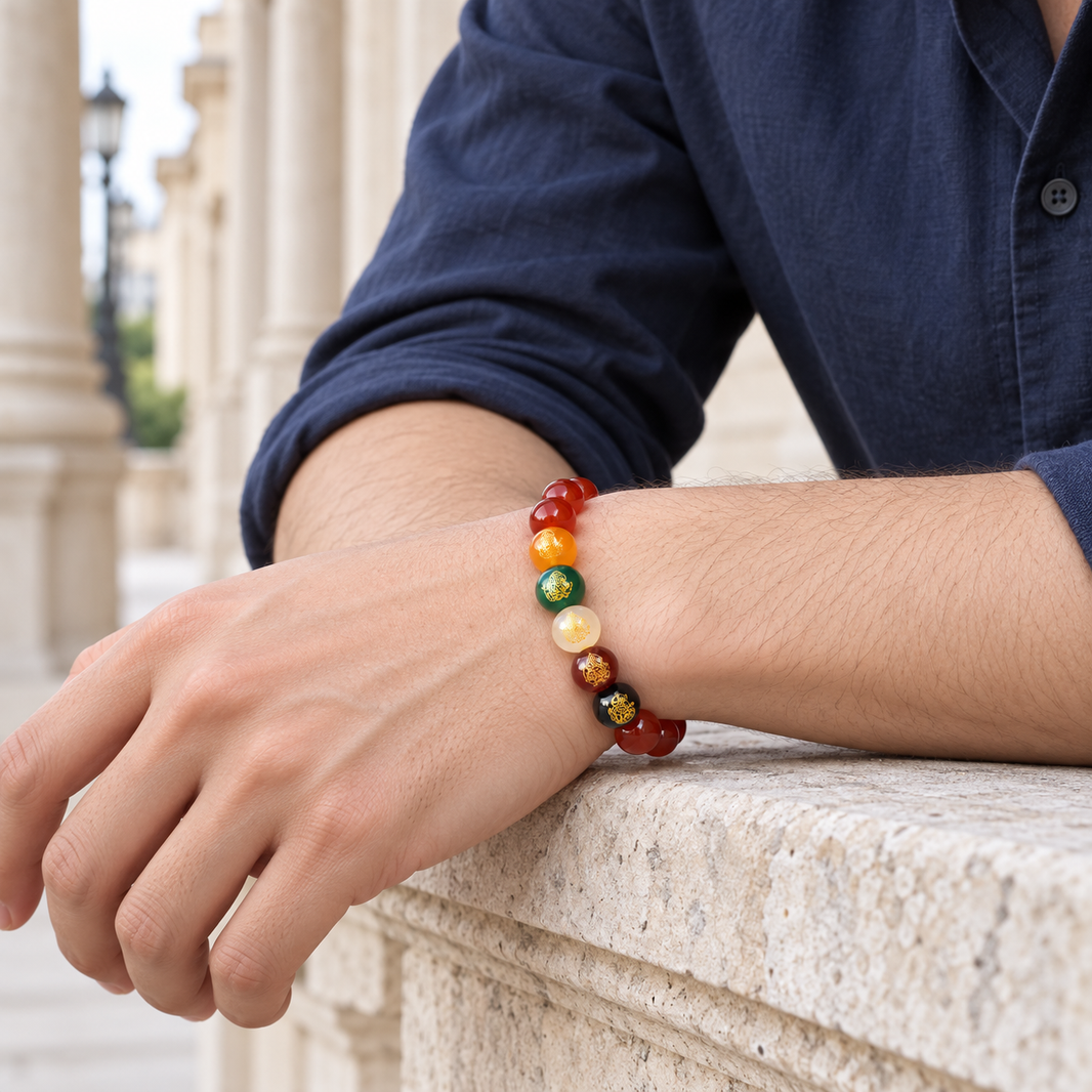 Man wearing the Five Elements Agate Bracelet by a pale stone colonnade