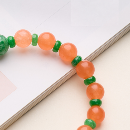 Close-up of orange beads and green spacers