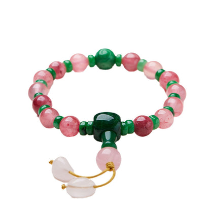 Pink patterned bead bracelet with green accents on a white background